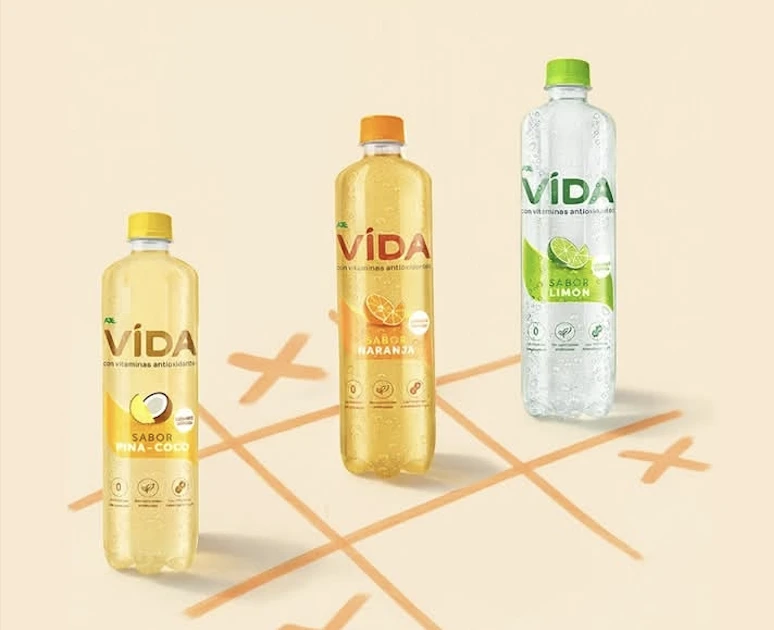 Botellas de Agua VIDA en sabores piña-coco, limón y naranja sobre fondo fresco y natural.