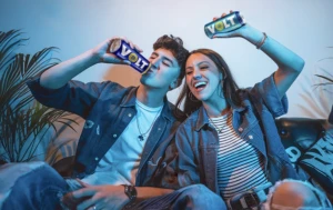 Aficionados viendo fútbol durante una reunión mientras consumen bebidas energéticas VOLT.